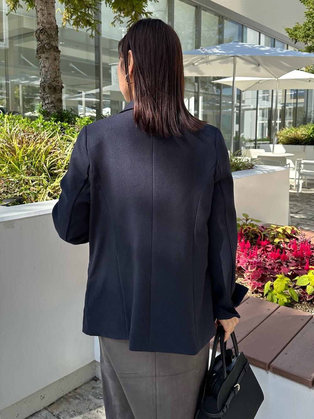 ブルー系のテーラードジャケット、ブルー系のニット/セーター、グレー系のスカートを着用したレディースの秋コーディネートの5枚目の写真