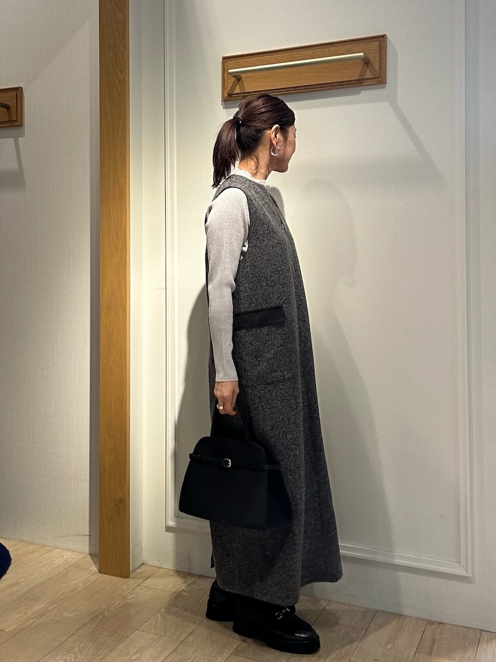 グレー系のワンピース、ブラック系のトートバッグを着用したレディースの秋コーディネートの3枚目の写真