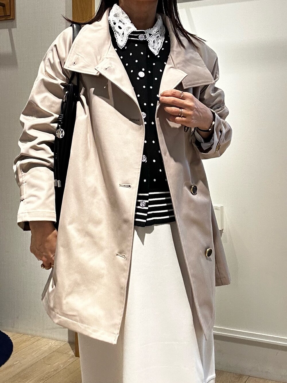 ベージュ系のその他アウター、ブラック系のニット/セーター、ホワイト系のスカートを着用したレディースの冬コーディネートの6枚目の写真