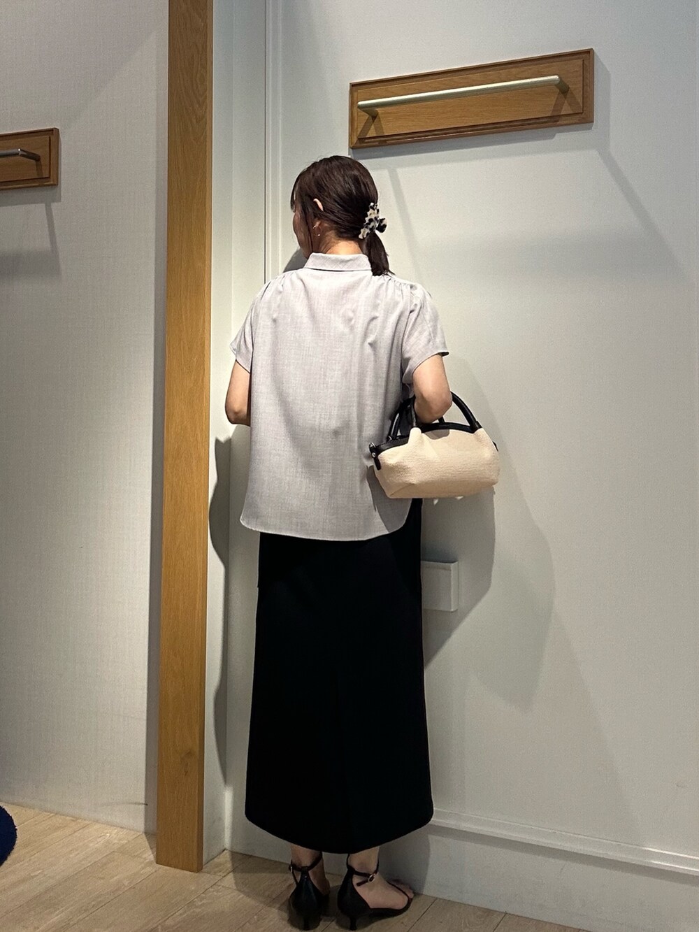 グレー系のシャツ/ブラウス、ブラック系のスカート、ブラック系のバックパック/リュックを着用したレディースの夏コーディネートの5枚目の写真