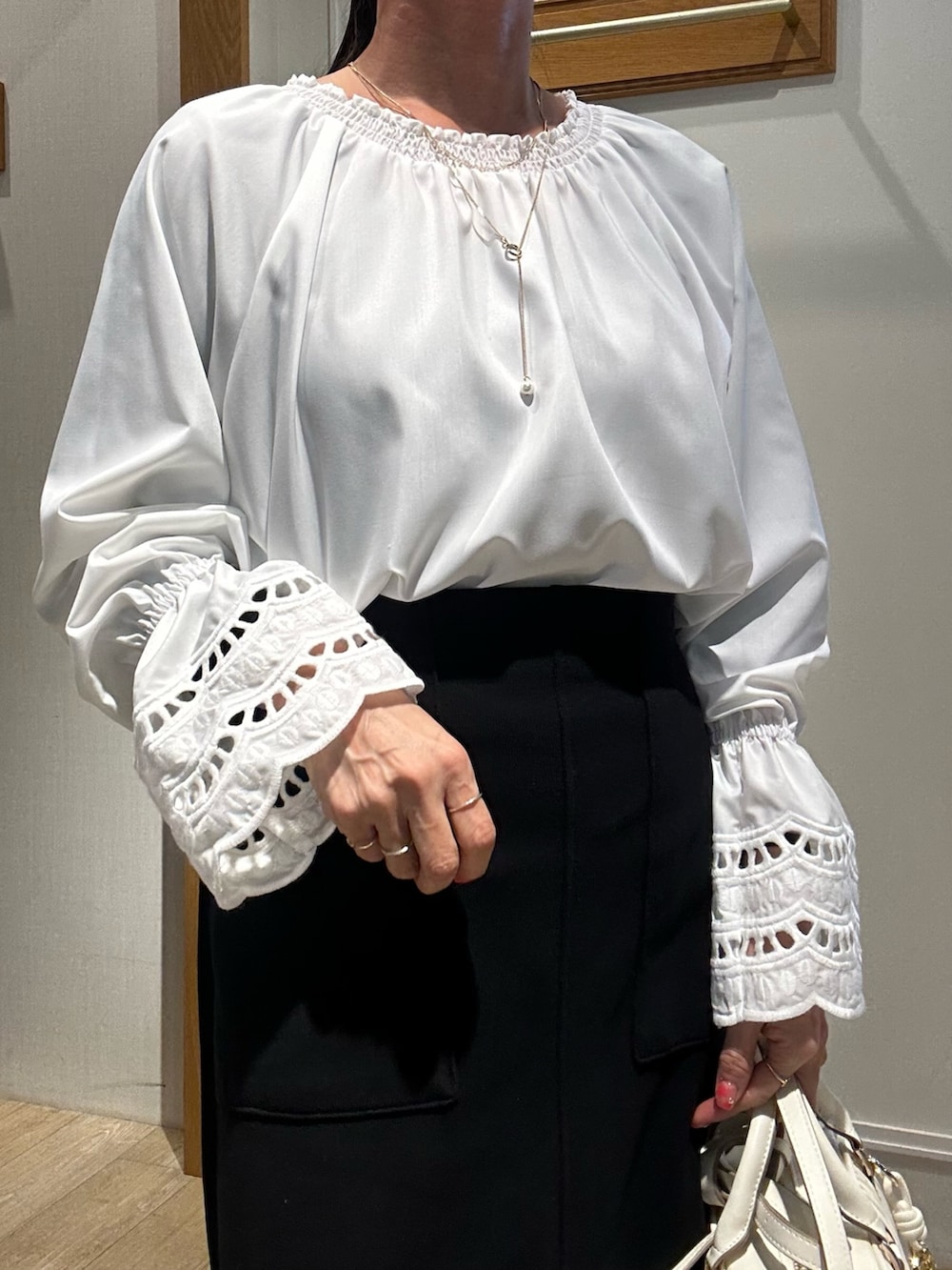 ホワイト系のショルダーバッグ、ホワイト系のシャツ/ブラウス、ベージュ系のブルゾンを着用したレディースの冬コーディネートの9枚目の写真