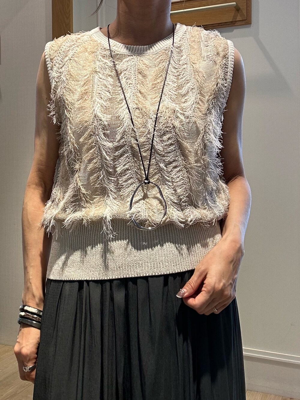 ベージュ系のニット/セーター、グレー系のその他パンツ、グレー系のショルダーバッグを着用したレディースの夏コーディネートの8枚目の写真