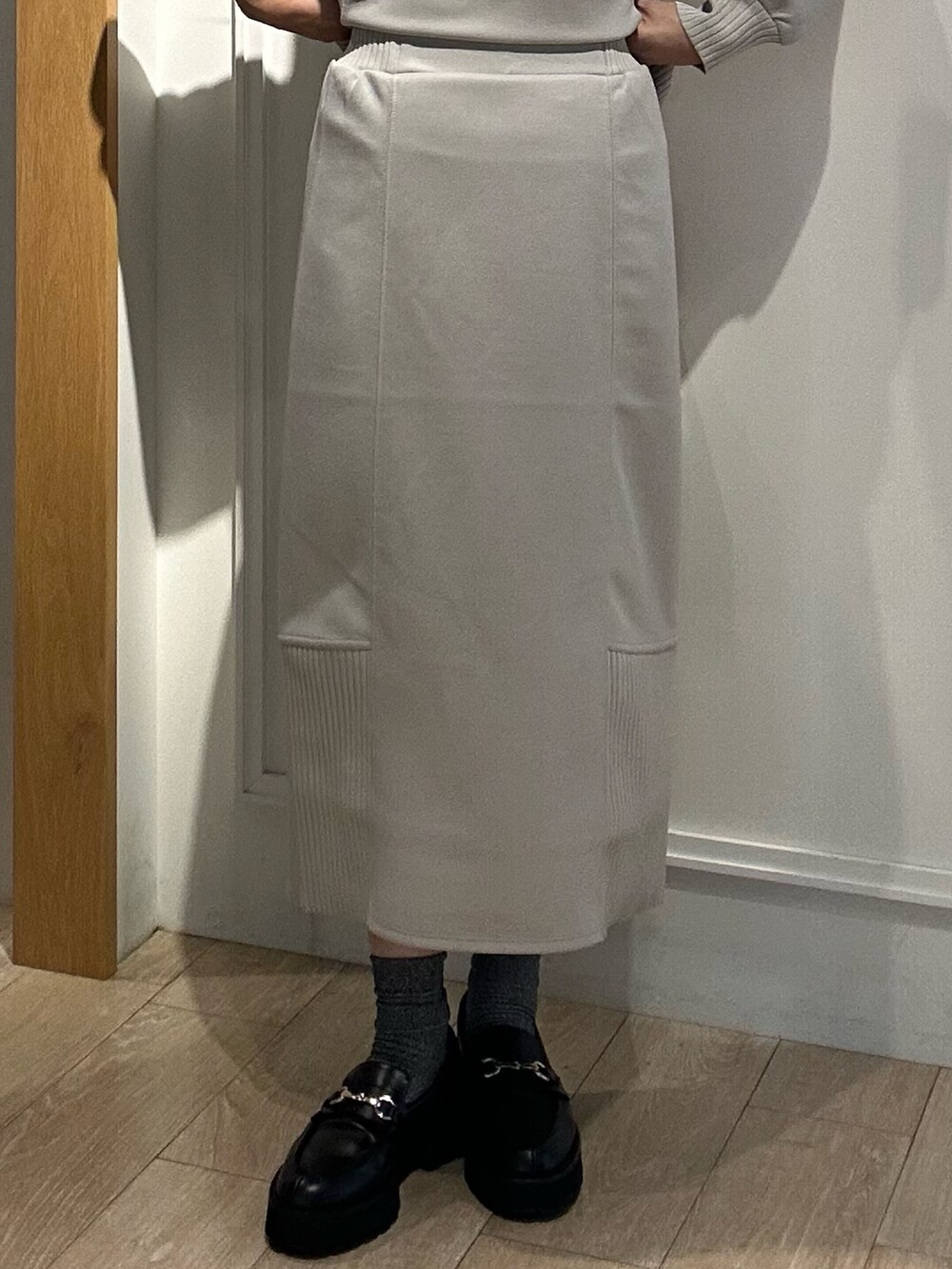 グレー系のトートバッグ、ベージュ系のスカート、ベージュ系のTシャツ/カットソーを着用したレディースの秋コーディネートの9枚目の写真