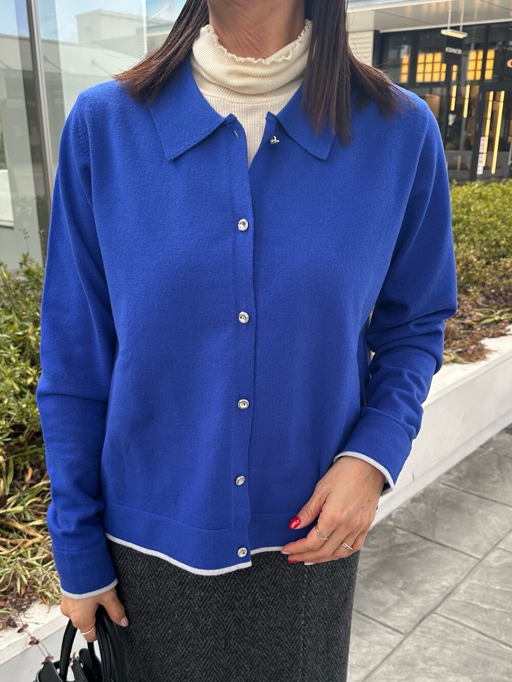 ブルー系のカーディガン/ボレロ、グレー系のスカート、ブラック系のトートバッグを着用したレディースの冬コーディネートの4枚目の写真