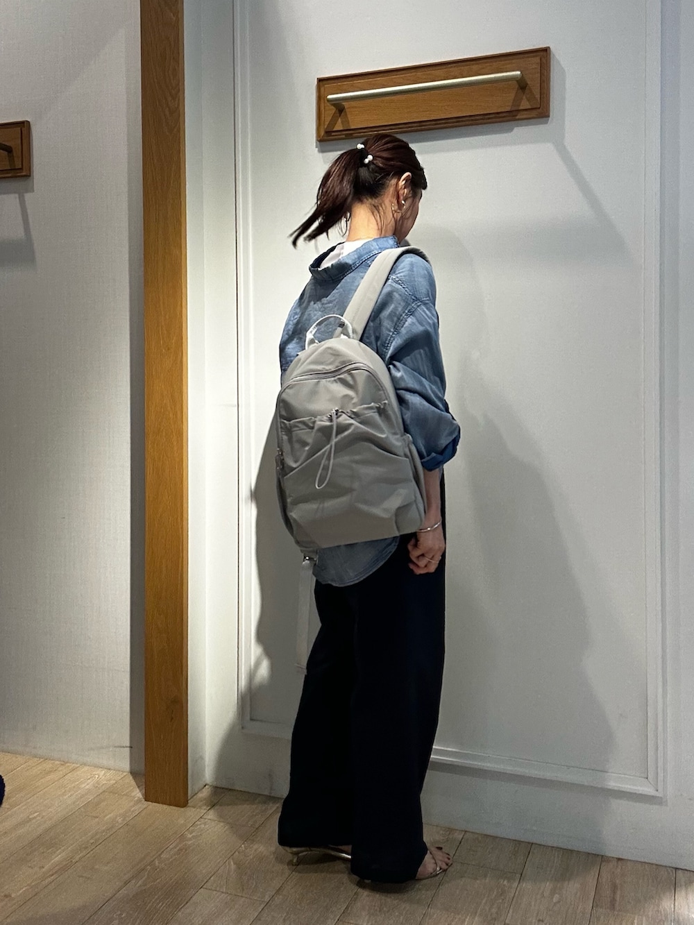 グレー系のバックパック/リュック、ホワイト系のTシャツ/カットソー、ブルー系のシャツ/ブラウスを着用したレディースの春コーディネートの4枚目の写真
