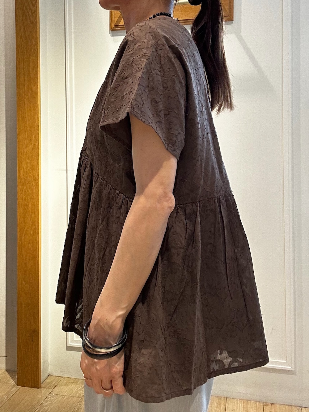 ブラウン系のシャツ/ブラウス、グレー系のその他パンツ、ゴールド系のトートバッグを着用したレディースの夏コーディネートの6枚目の写真