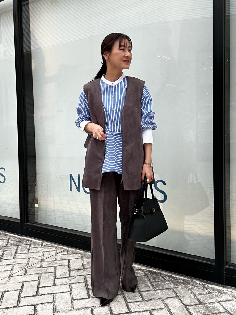 グレー系のブルゾン、グレー系のその他パンツ、ホワイト系のニット/セーターを着用したレディースの冬コーディネートの4枚目の写真