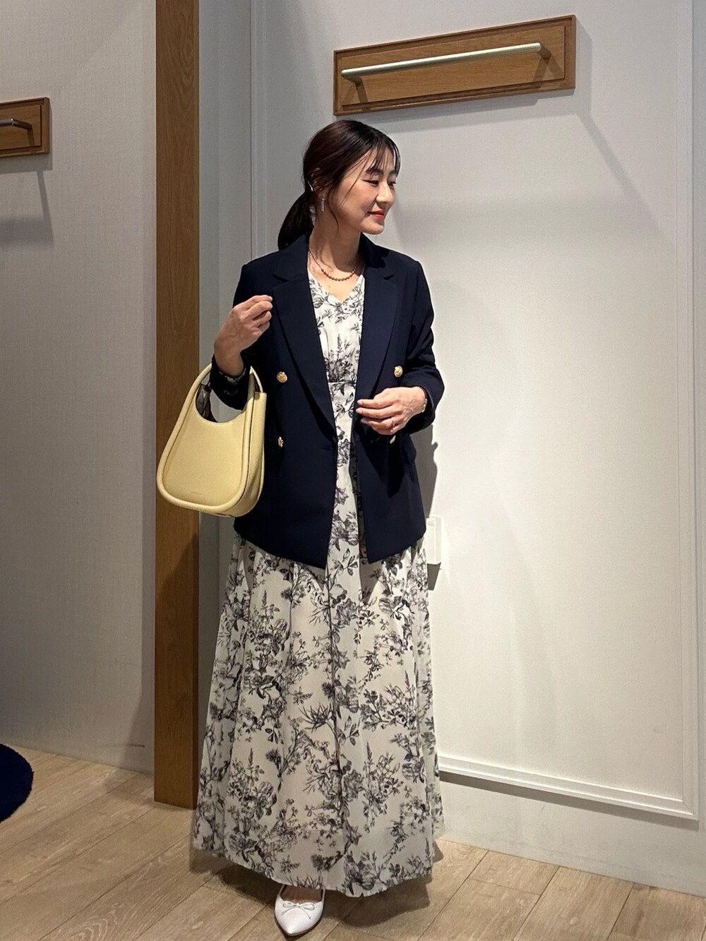 ベージュ系のワンピース、ブルー系のテーラードジャケットを着用したレディースの春コーディネートの10枚目の写真