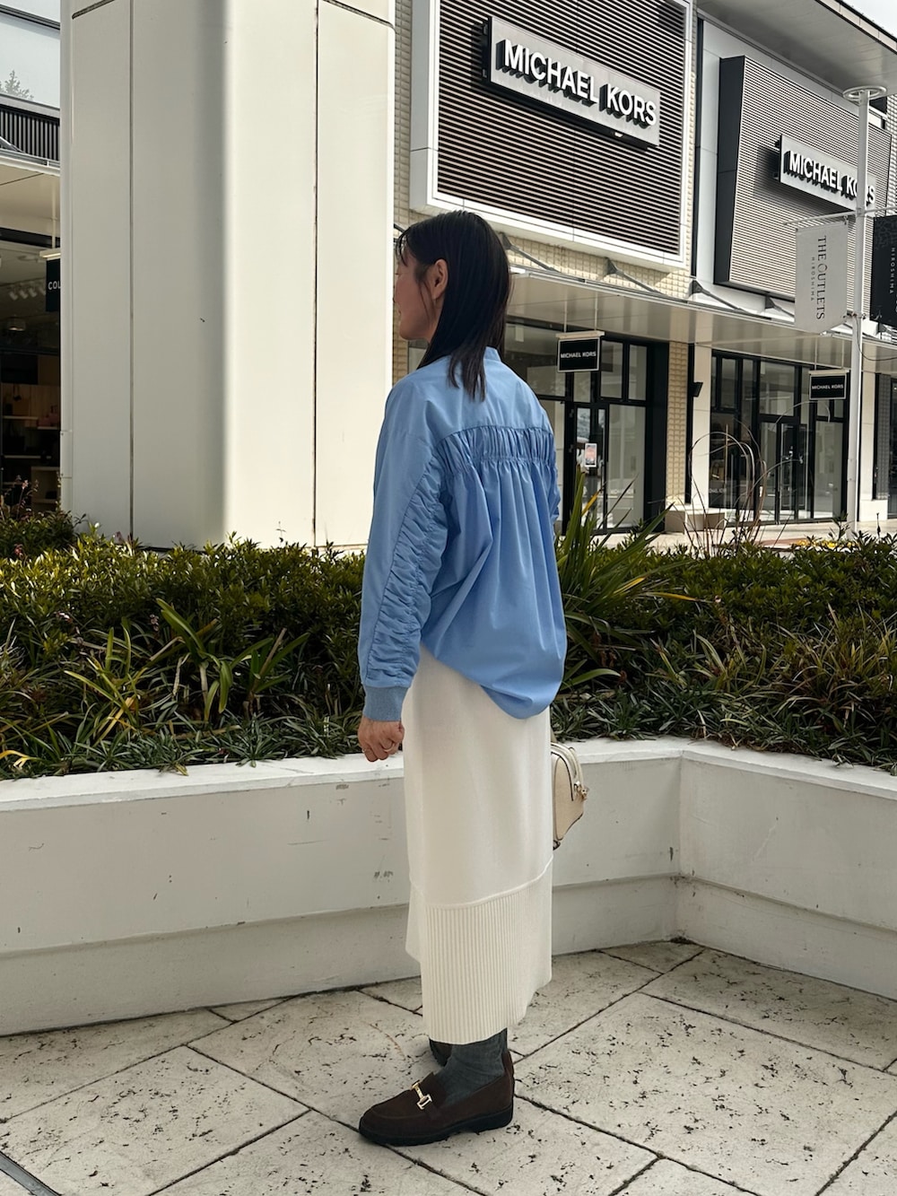 ホワイト系のパーカー、ブルー系のシャツ/ブラウス、ホワイト系のスカートを着用したレディースの冬コーディネートの3枚目の写真