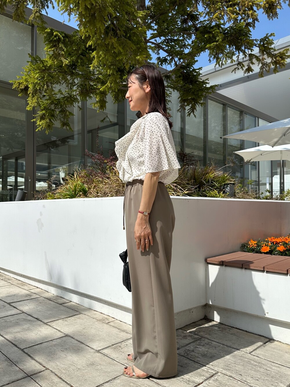 ホワイト系のシャツ/ブラウス、グリーン系のその他パンツ、ブラック系のショルダーバッグを着用したレディースの春コーディネートの2枚目の写真