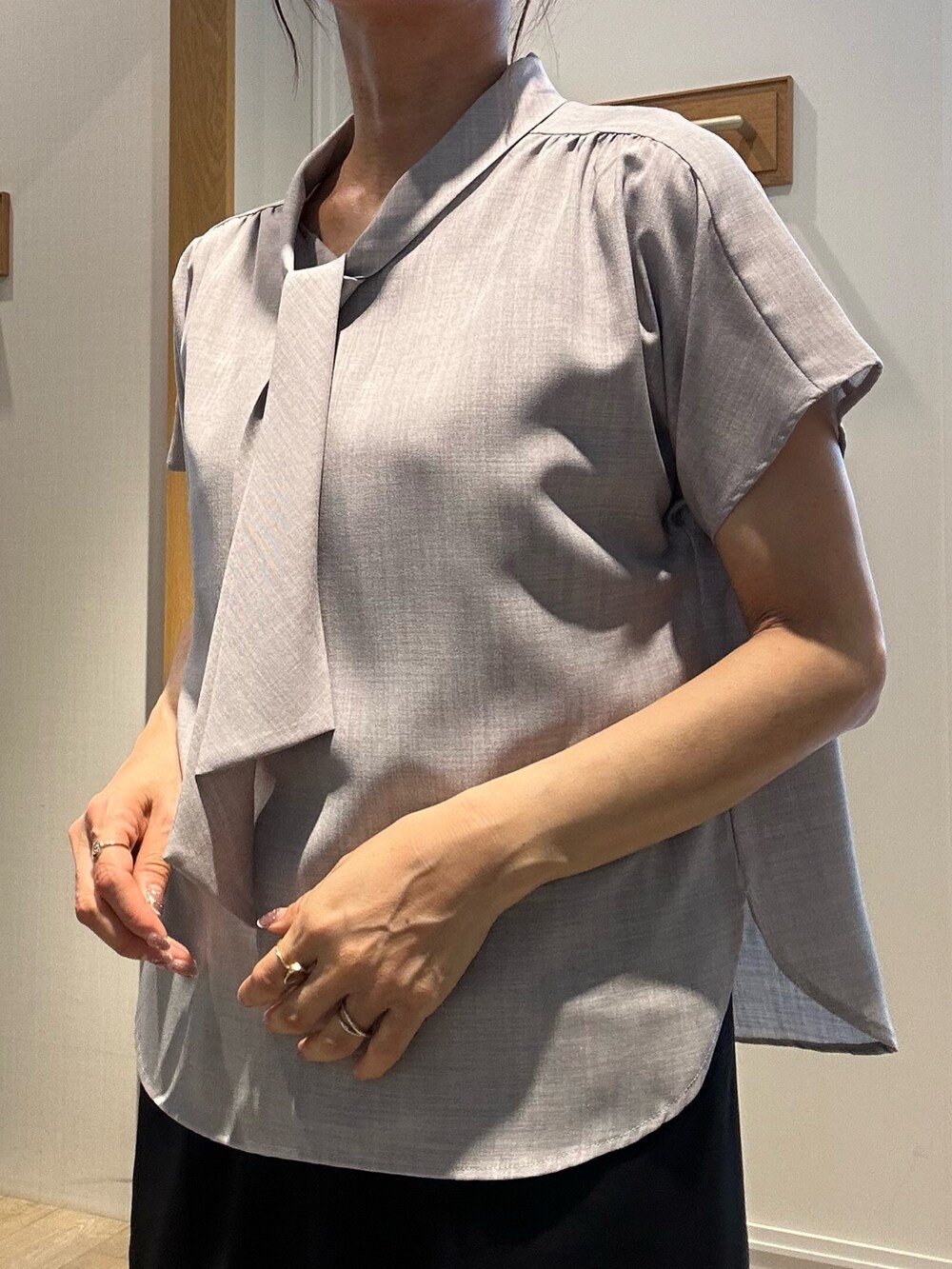 グレー系のシャツ/ブラウス、ブラック系のスカート、ブラック系のバックパック/リュックを着用したレディースの夏コーディネートの7枚目の写真
