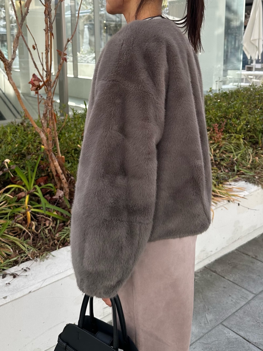 グレー系のブルゾン、グレー系のニット/セーター、ピンク系のスカートを着用したレディースの冬コーディネートの5枚目の写真