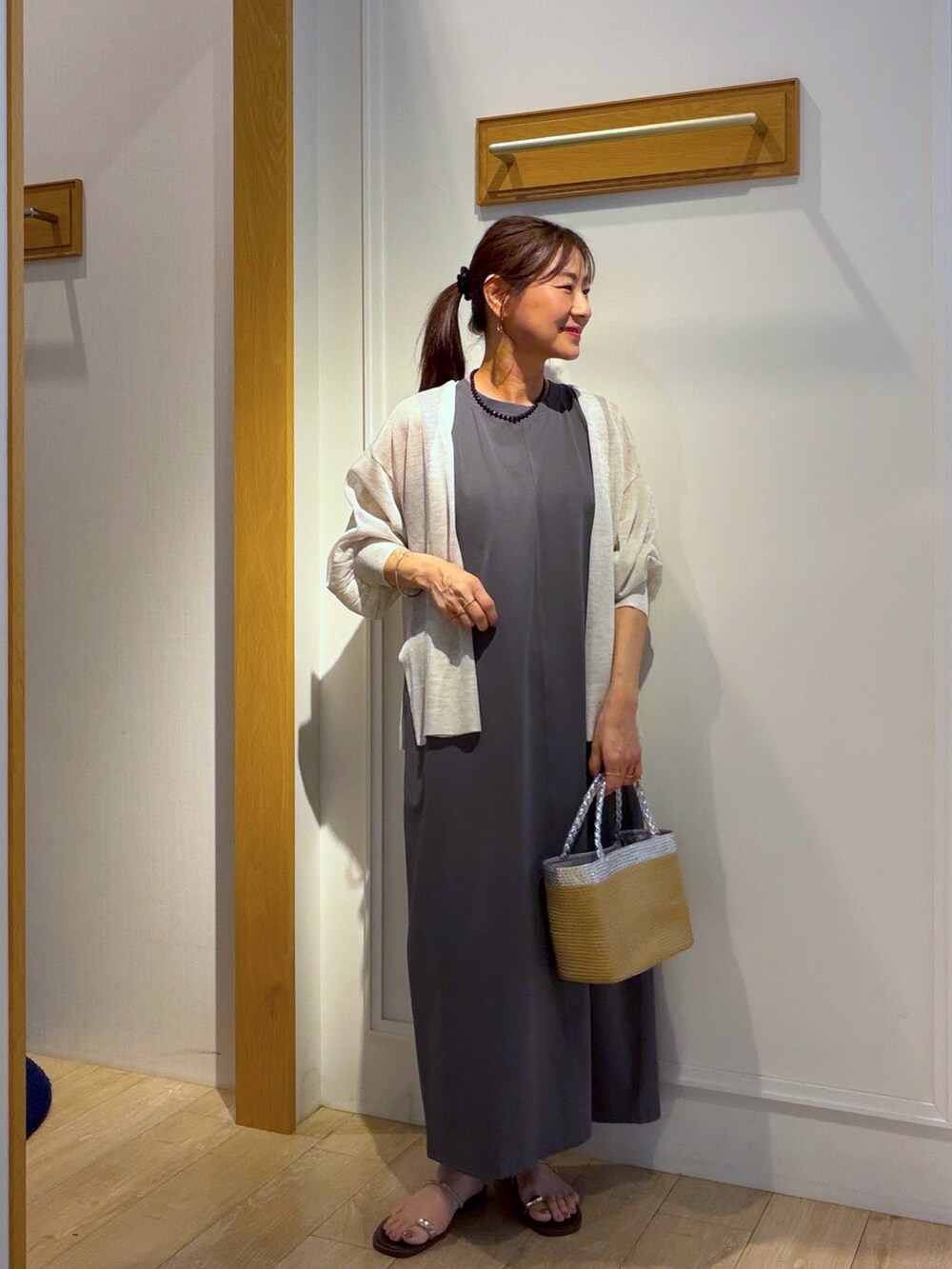 グレー系のワンピース、ベージュ系のカーディガン/ボレロ、ブラック系のネックレスを着用したレディースの夏コーディネートの9枚目の写真