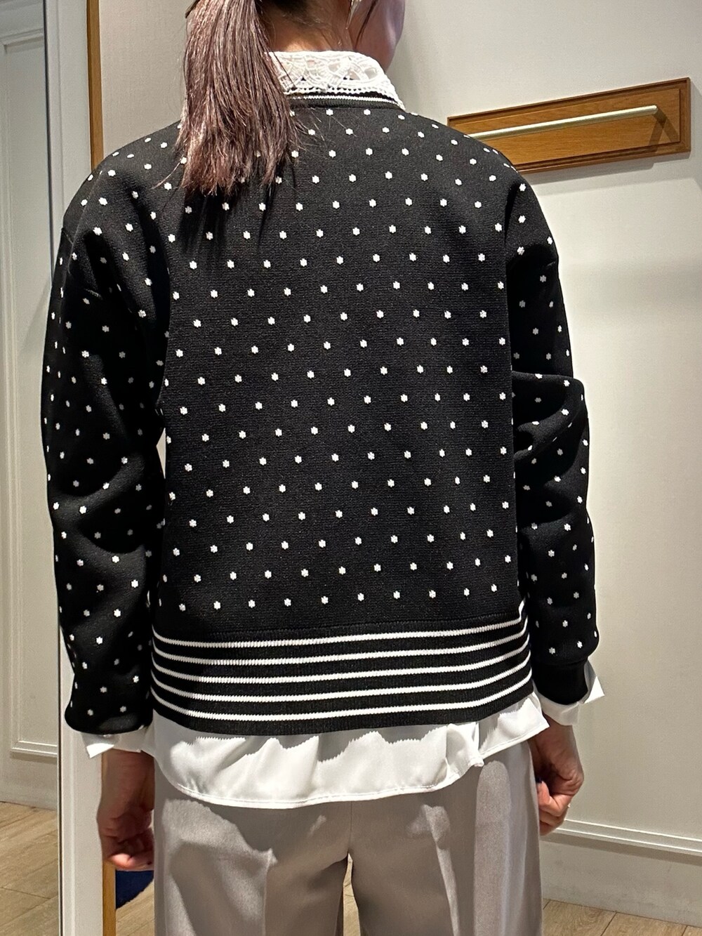 ブラック系のニット/セーター、ブラック系のショルダーバッグ、ホワイト系のシャツ/ブラウスを着用したレディースの冬コーディネートの9枚目の写真