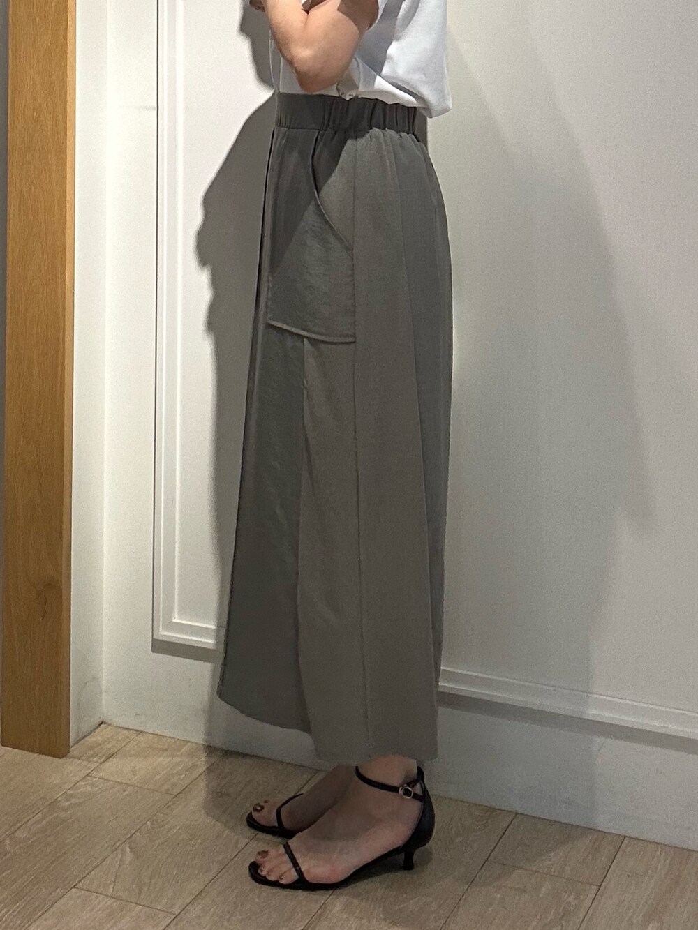 グリーン系のスカート、ホワイト系のTシャツ/カットソー、ブラック系のボストンバッグを着用したレディースの夏コーディネートの7枚目の写真