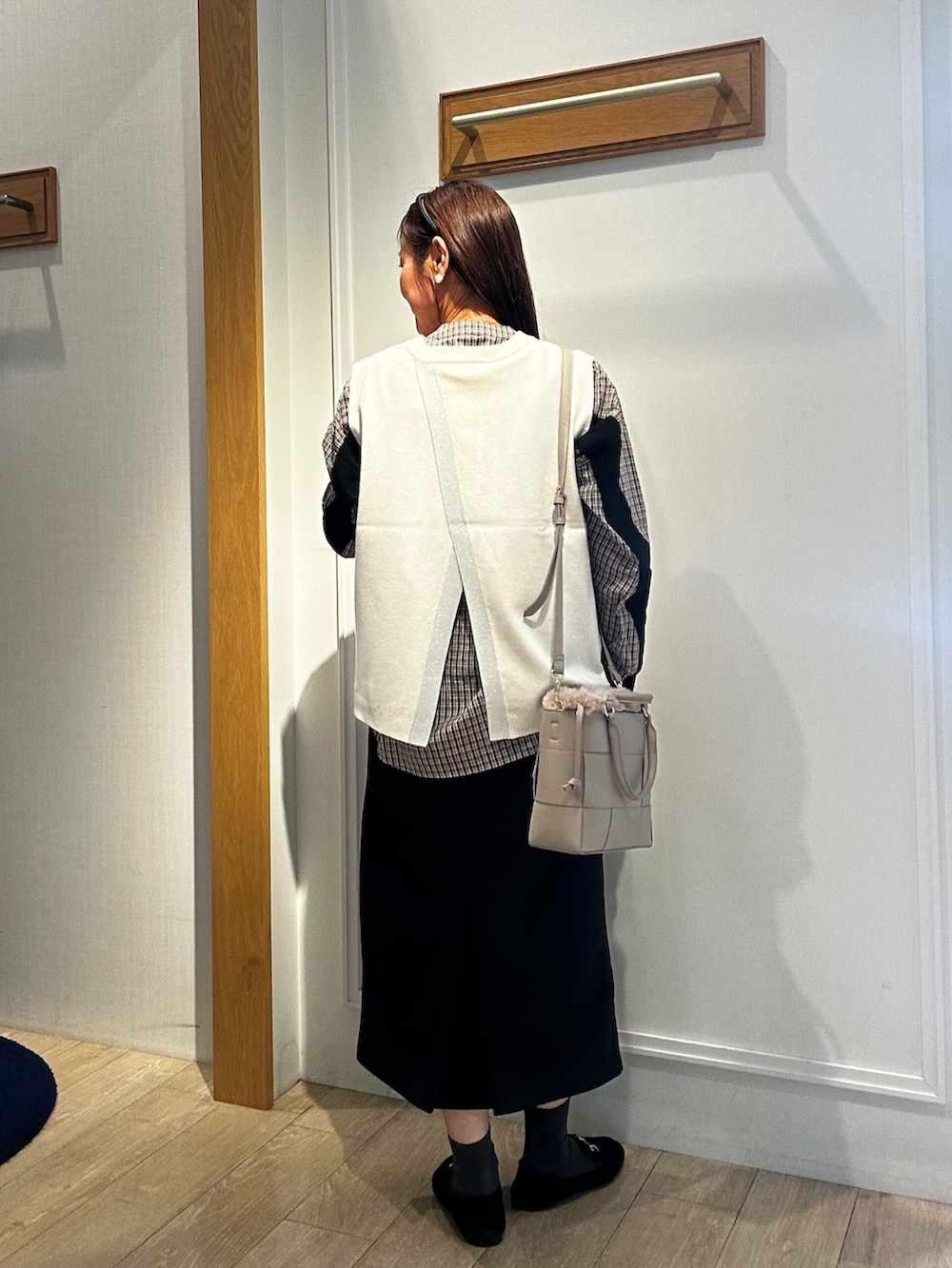 ブラック系のパーカー、ホワイト系のニット/セーター、ブラウン系のシャツ/ブラウスを着用したレディースの秋コーディネートの7枚目の写真
