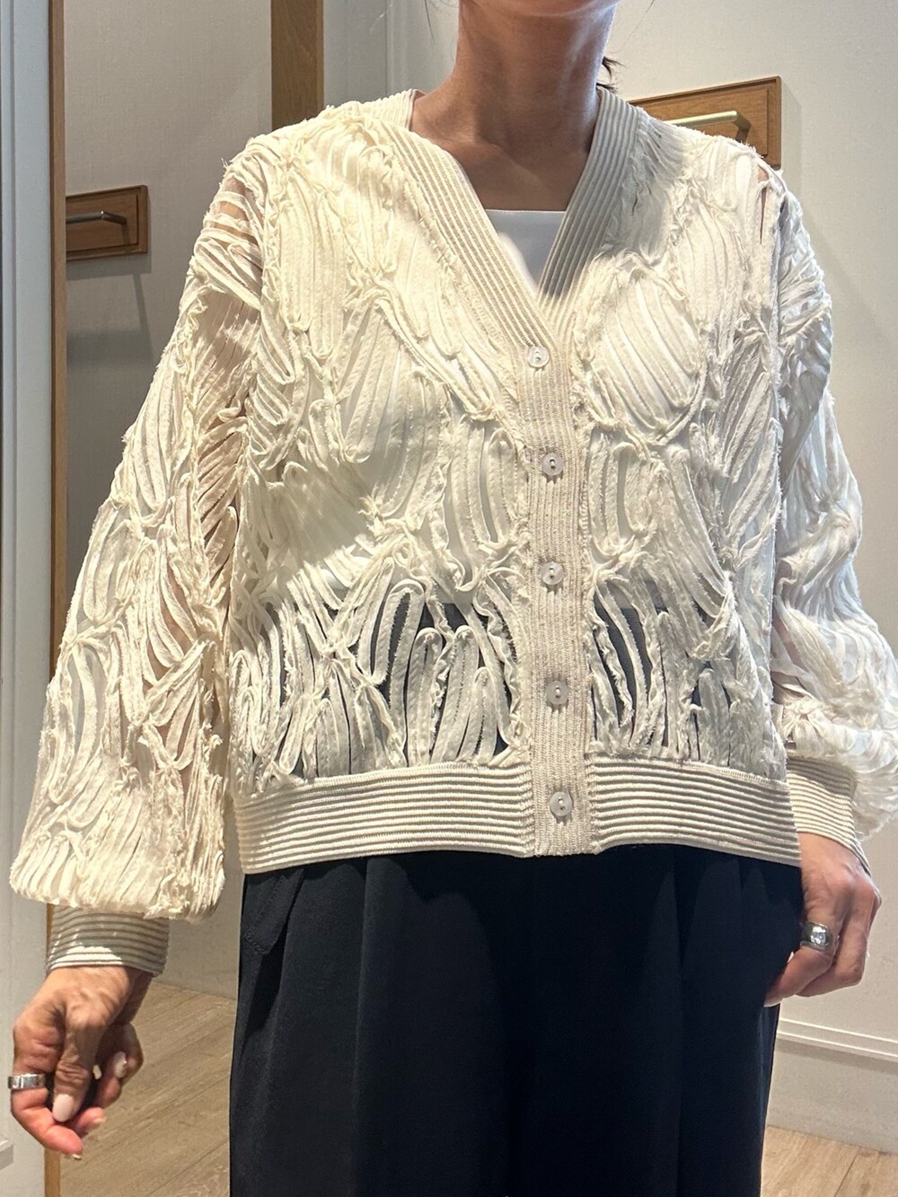 ホワイト系のカーディガン/ボレロ、シルバー系のネックレスを着用したレディースの冬コーディネートの5枚目の写真