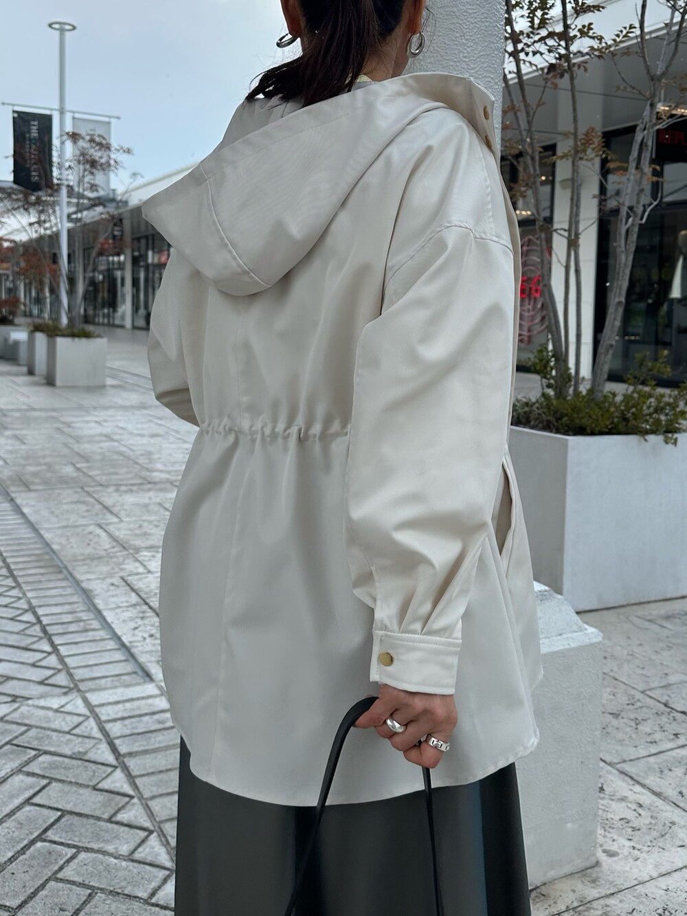 ホワイト系のブルゾン、イエロー系のシャツ/ブラウス、グリーン系のスカートを着用したレディースの冬コーディネートの9枚目の写真