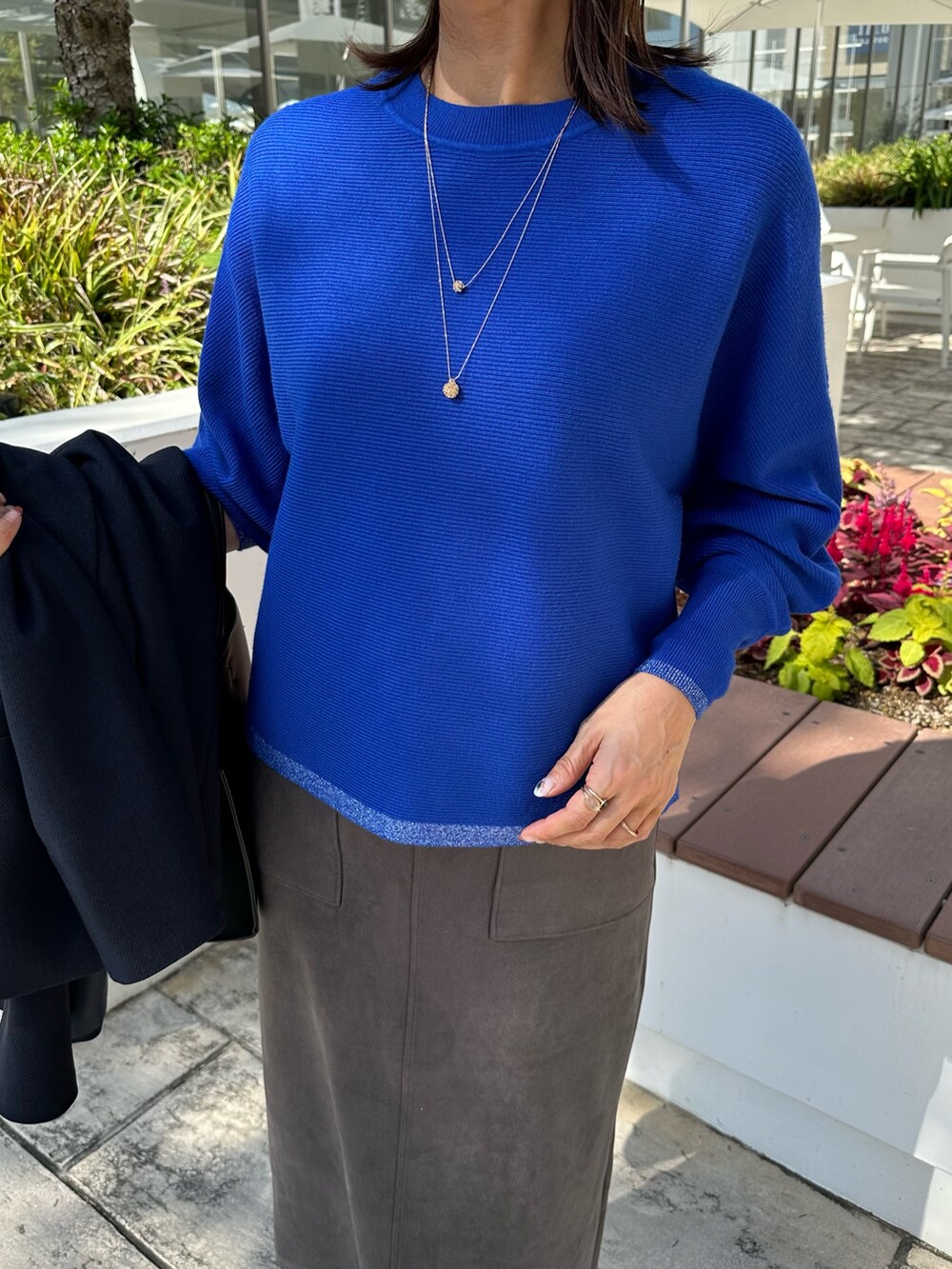 ブルー系のテーラードジャケット、ブルー系のニット/セーター、グレー系のスカートを着用したレディースの秋コーディネートの9枚目の写真