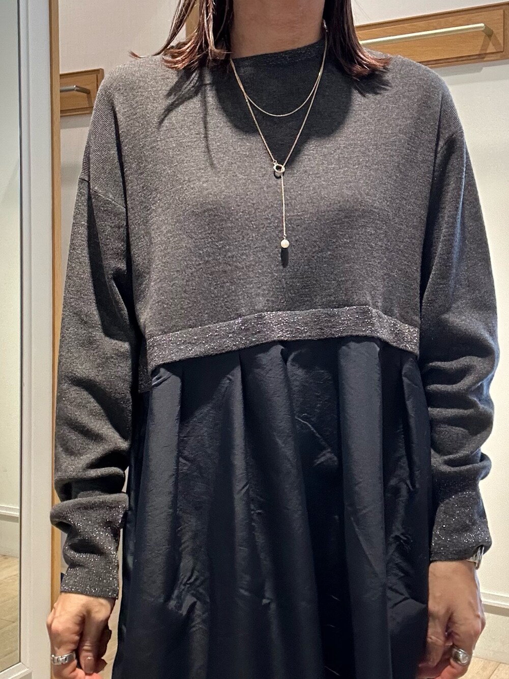 グレー系のワンピース、ゴールド系のショルダーバッグを着用したレディースの冬コーディネートの4枚目の写真