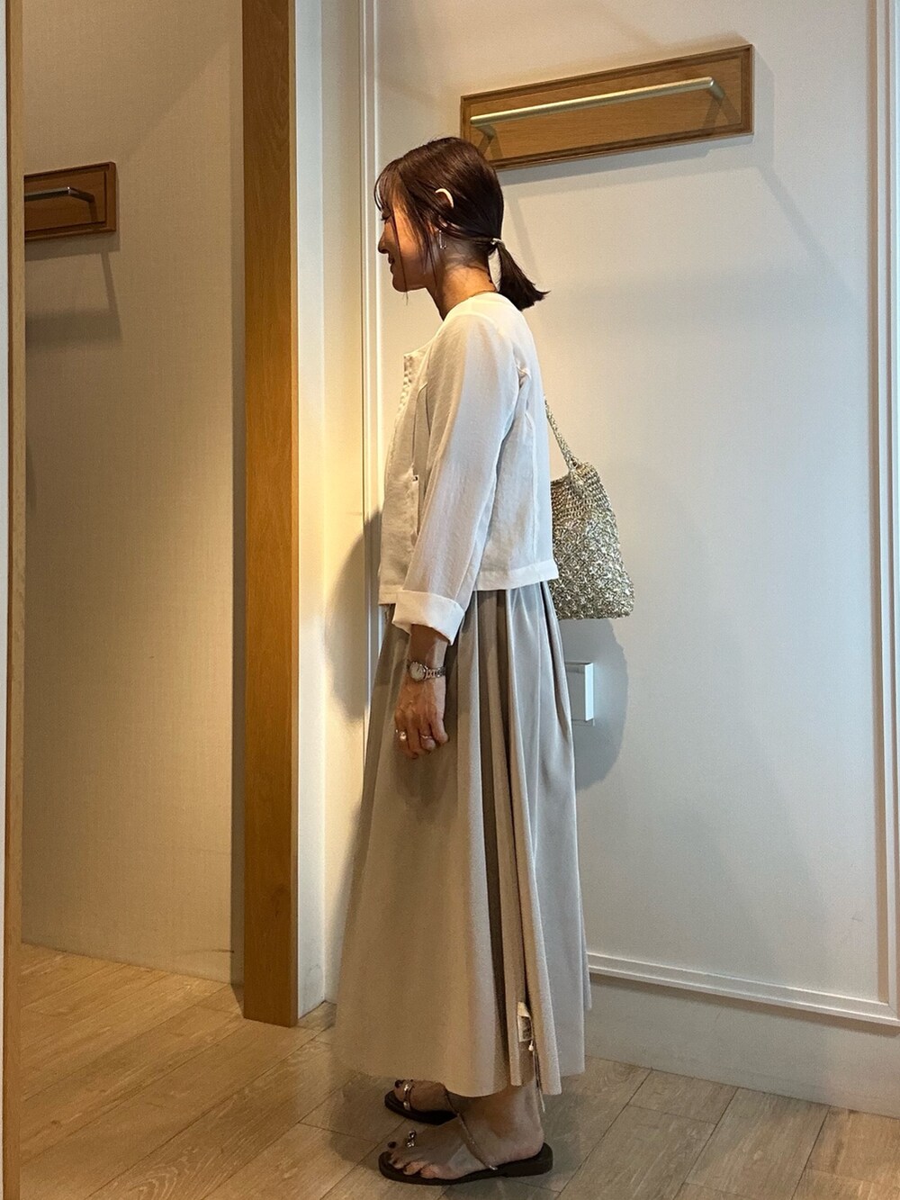 ホワイト系のブルゾン、グレー系のTシャツ/カットソー、グリーン系のスカートを着用したレディースの春コーディネートの2枚目の写真