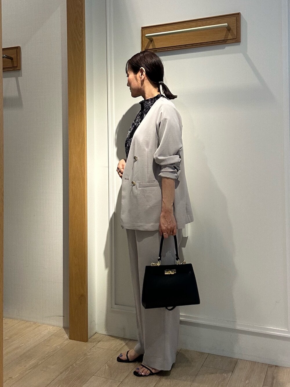 ベージュ系のノーカラージャケット、ベージュ系のその他パンツ、ブラック系のショルダーバッグを着用したレディースの夏コーディネートの2枚目の写真