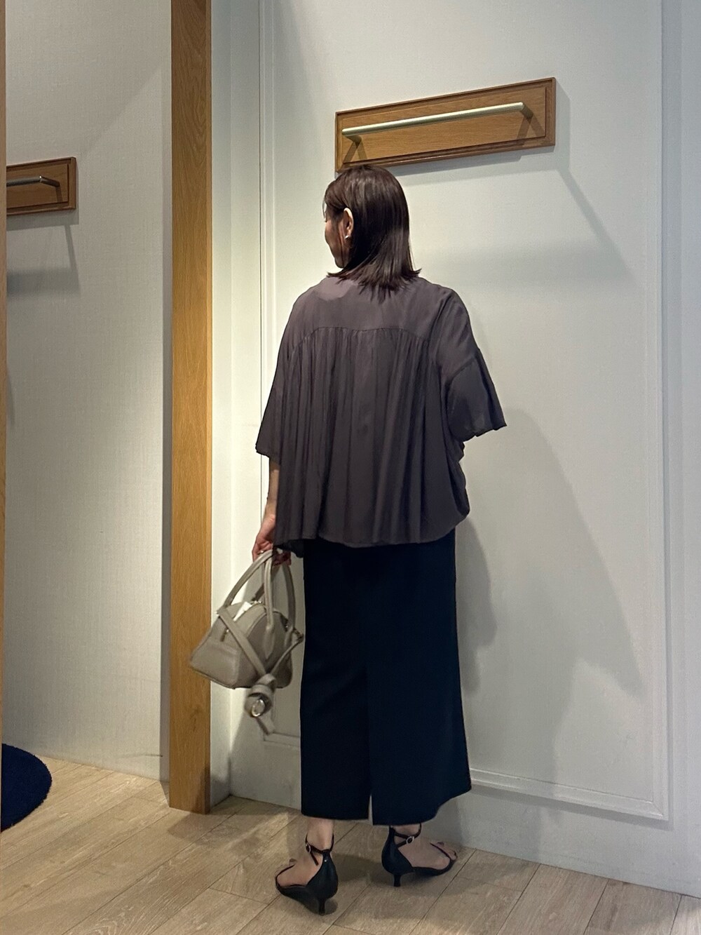 グレー系のシャツ/ブラウス、ブラック系のスカート、ベージュ系のボストンバッグを着用したレディースの夏コーディネートの4枚目の写真