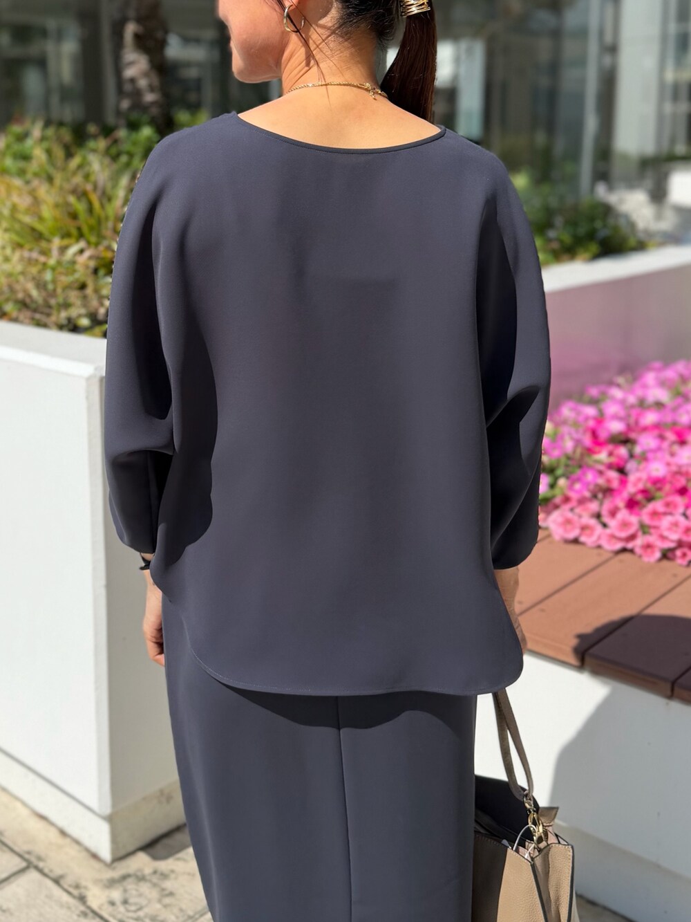 グレー系のシャツ/ブラウス、グレー系のスカート、ベージュ系のショルダーバッグを着用したレディースの夏コーディネートの6枚目の写真