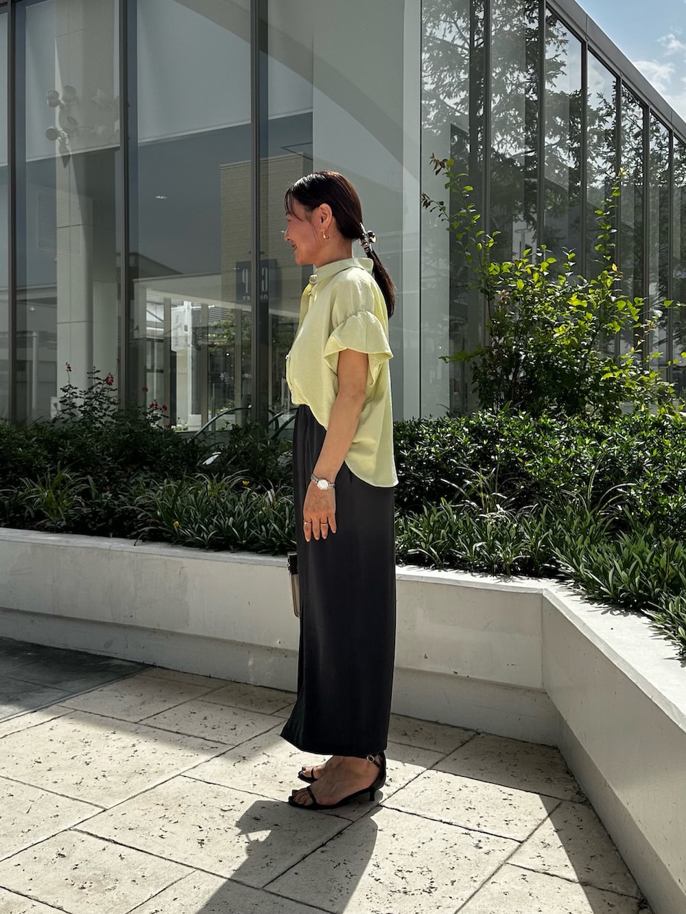 イエロー系のシャツ/ブラウス、ホワイト系のTシャツ/カットソー、グレー系のスカートを着用したレディースの夏コーディネートの2枚目の写真