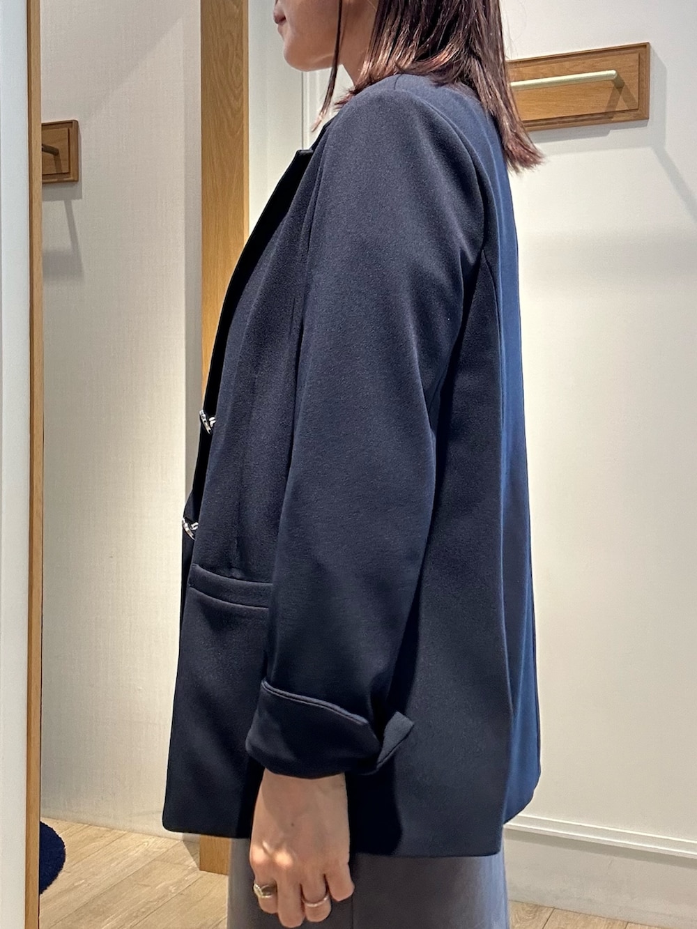 ホワイト系のニット/セーター、ブルー系のテーラードジャケット、グレー系のスカートを着用したレディースの秋コーディネートの6枚目の写真