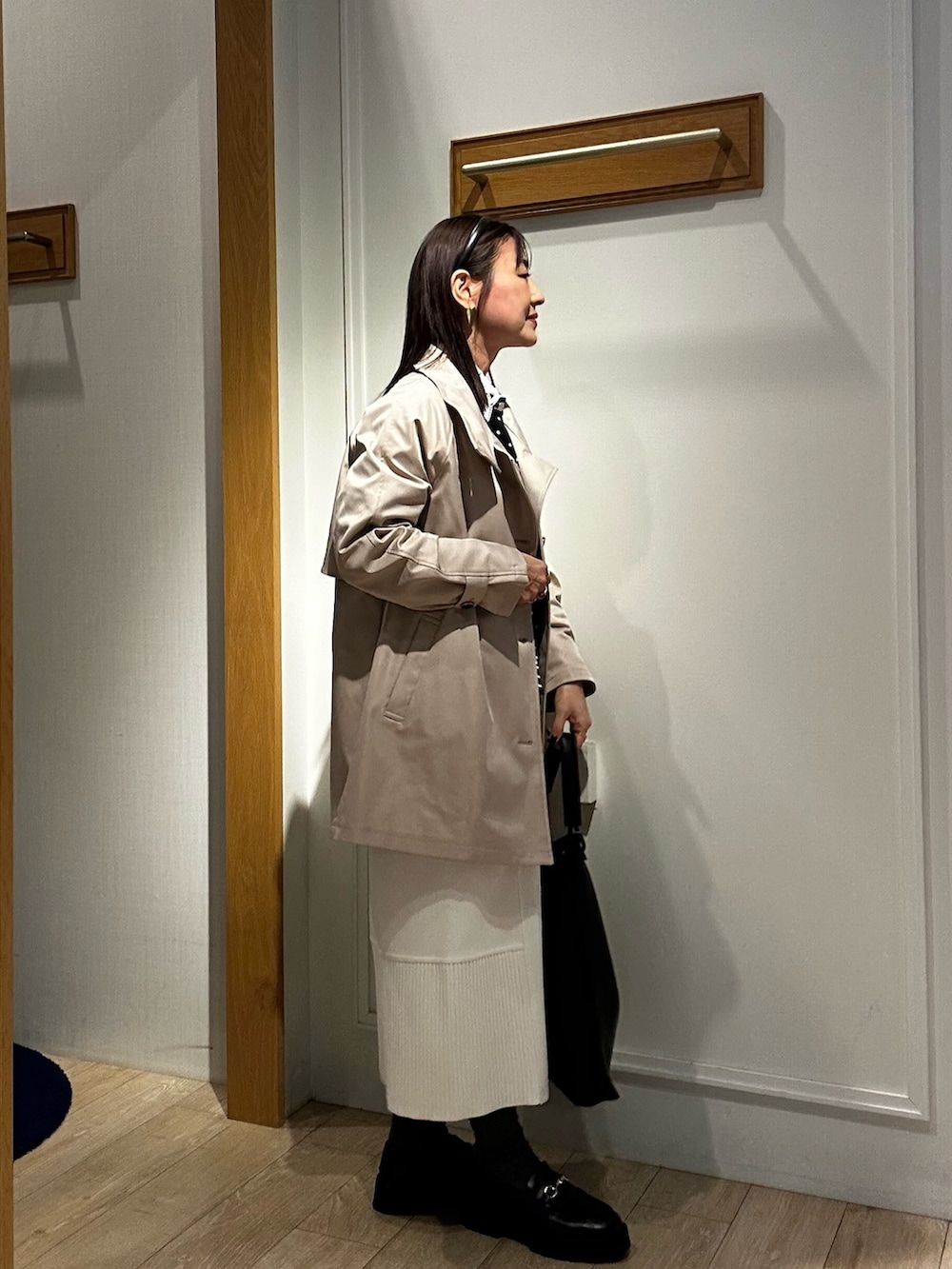 ベージュ系のその他アウター、ブラック系のニット/セーター、ホワイト系のスカートを着用したレディースの冬コーディネートの4枚目の写真