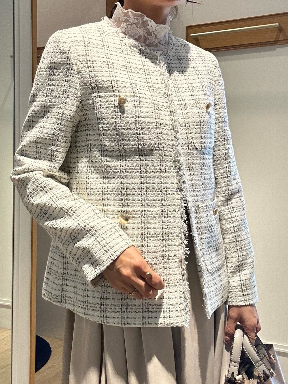 ホワイト系のノーカラージャケット、ベージュ系のスカート、ホワイト系のTシャツ/カットソーを着用したレディースの冬コーディネートの4枚目の写真