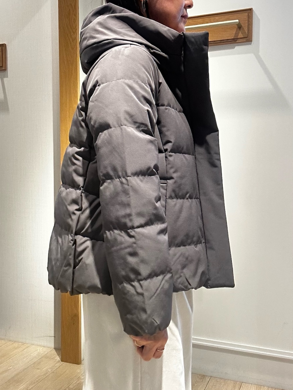 グレー系のダウンジャケット/コート、ピンク系のニット/セーター、ホワイト系のスカートを着用したレディースの冬コーディネートの6枚目の写真