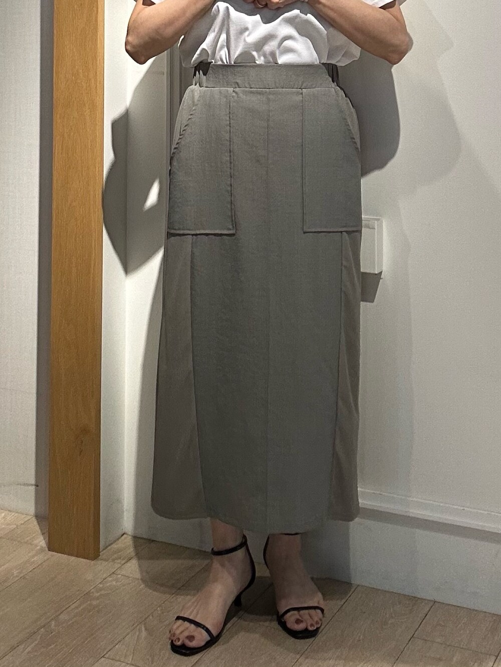 グリーン系のスカート、ホワイト系のTシャツ/カットソー、ブラック系のボストンバッグを着用したレディースの夏コーディネートの6枚目の写真