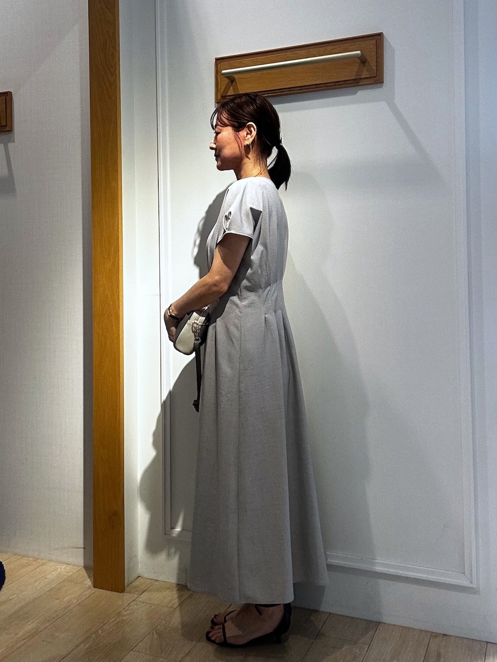 ベージュ系のワンピース、ブルー系のカーディガン/ボレロ、グレー系のショルダーバッグを着用したレディースの春コーディネートの4枚目の写真