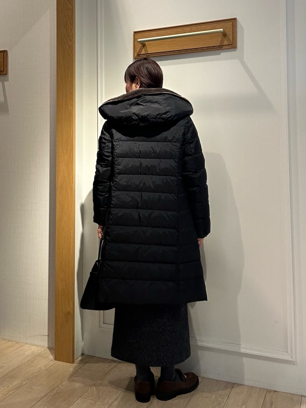 ブラック系のダウンジャケット/コート、グレー系のスカート、ブラック系のトートバッグを着用したレディースの冬コーディネートの3枚目の写真