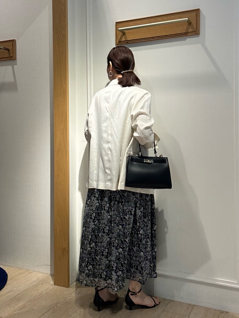 ブラック系のワンピース、ホワイト系のテーラードジャケット、ブラック系のショルダーバッグを着用したレディースの夏コーディネートの4枚目の写真