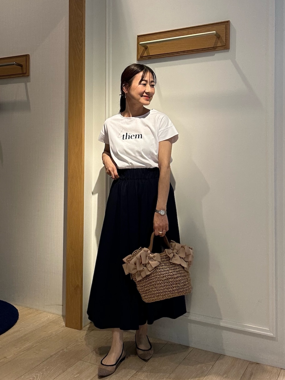 ベージュ系のニット/セーター、ホワイト系のTシャツ/カットソー、ブルー系のスカートを着用したレディースの春コーディネートの9枚目の写真