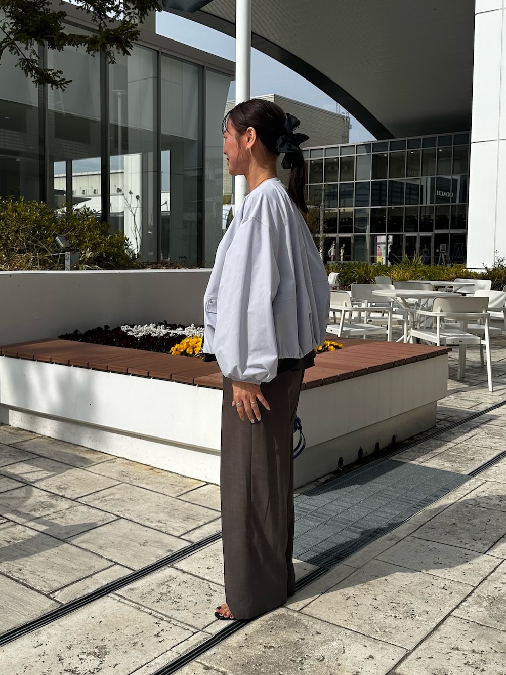 ブルー系のブルゾン、グリーン系のシャツ/ブラウス、ブルー系のショルダーバッグを着用したレディースの春コーディネートの2枚目の写真