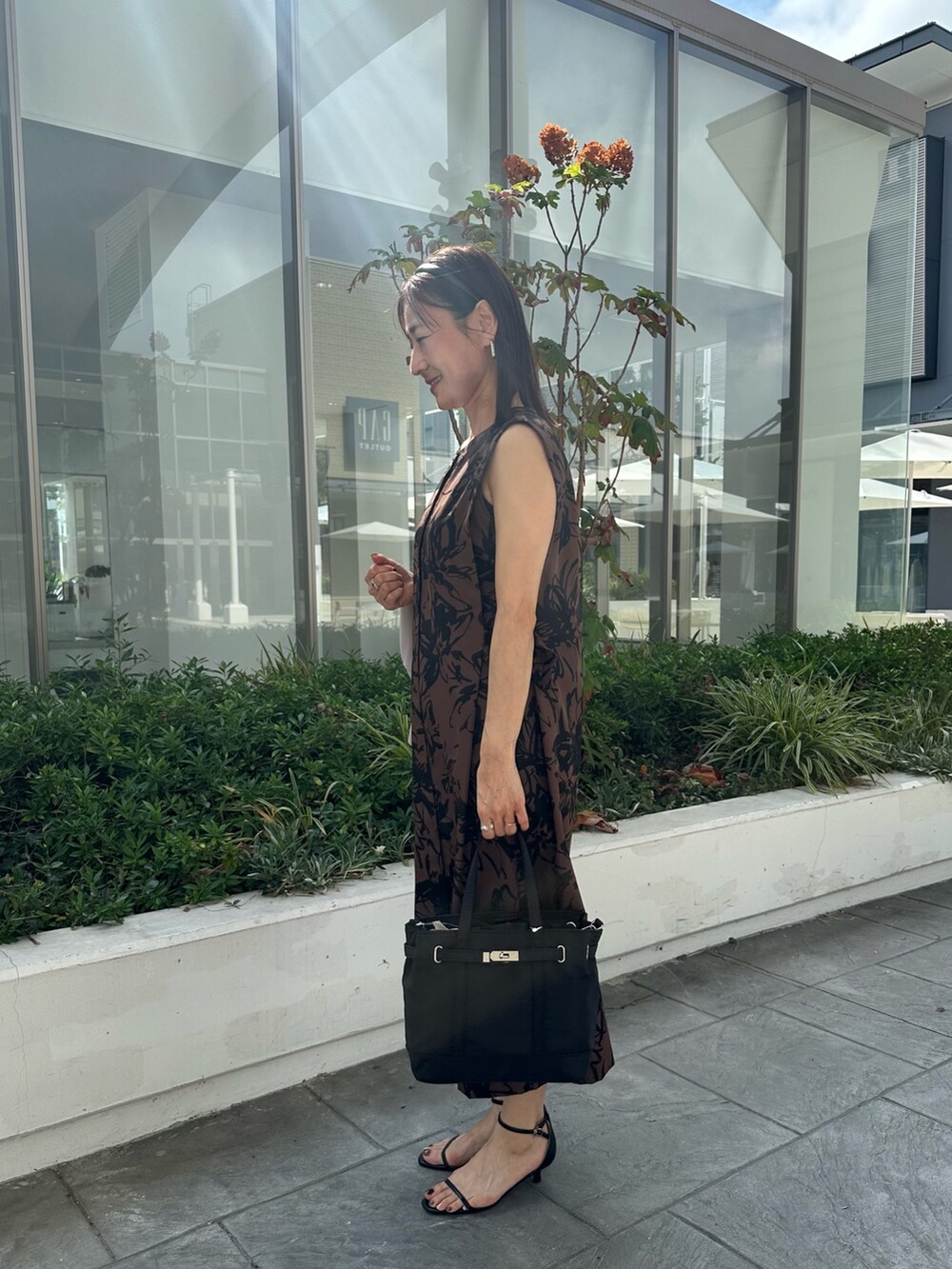 ベージュ系のワンピース、ブラック系のトートバッグ、ベージュ系のノーカラージャケットを着用したレディースの秋コーディネートの2枚目の写真