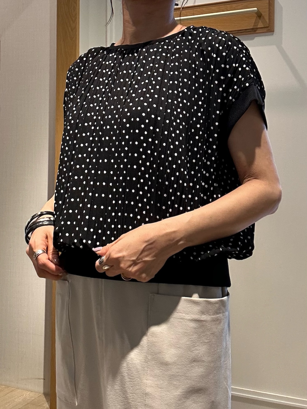 ベージュ系のスカート、ブラック系のショルダーバッグ、ブラック系のサンダルを着用したレディースの夏コーディネートの6枚目の写真