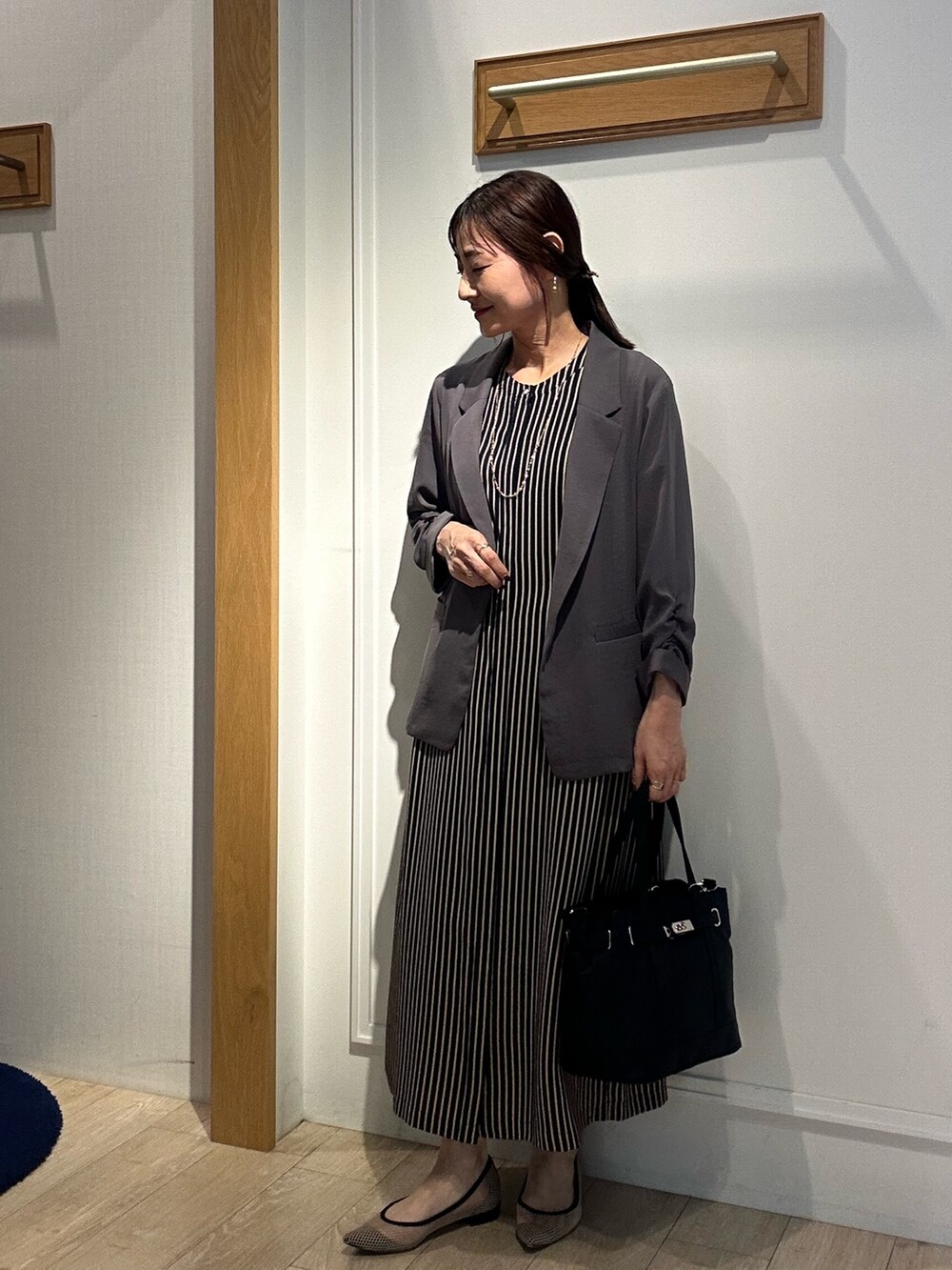 グレー系のテーラードジャケット、ブルー系のテーラードジャケット、ブラック系のトートバッグを着用したレディースの夏コーディネートの10枚目の写真