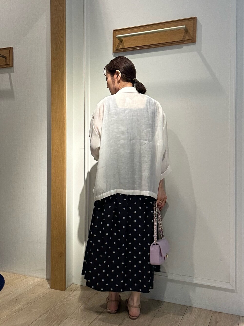 ホワイト系のテーラードジャケット、グレー系のTシャツ/カットソー、ブラック系のスカートを着用したレディースの春コーディネートの4枚目の写真