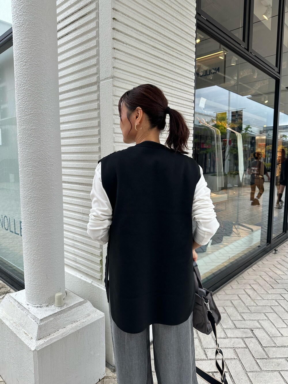 グレー系のデニムパンツ、ブラック系のニット/セーター、グレー系のトートバッグを着用したレディースの秋コーディネートの6枚目の写真