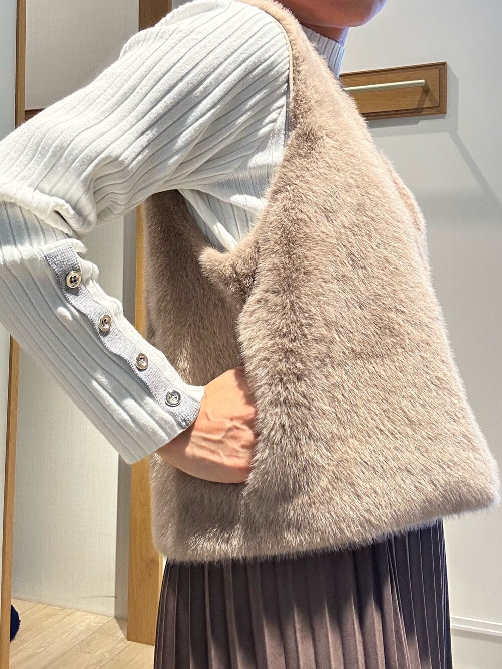 ホワイト系のニット/セーター、ブラウン系のスカート、ブラウン系のブルゾンを着用したレディースの秋コーディネートの6枚目の写真