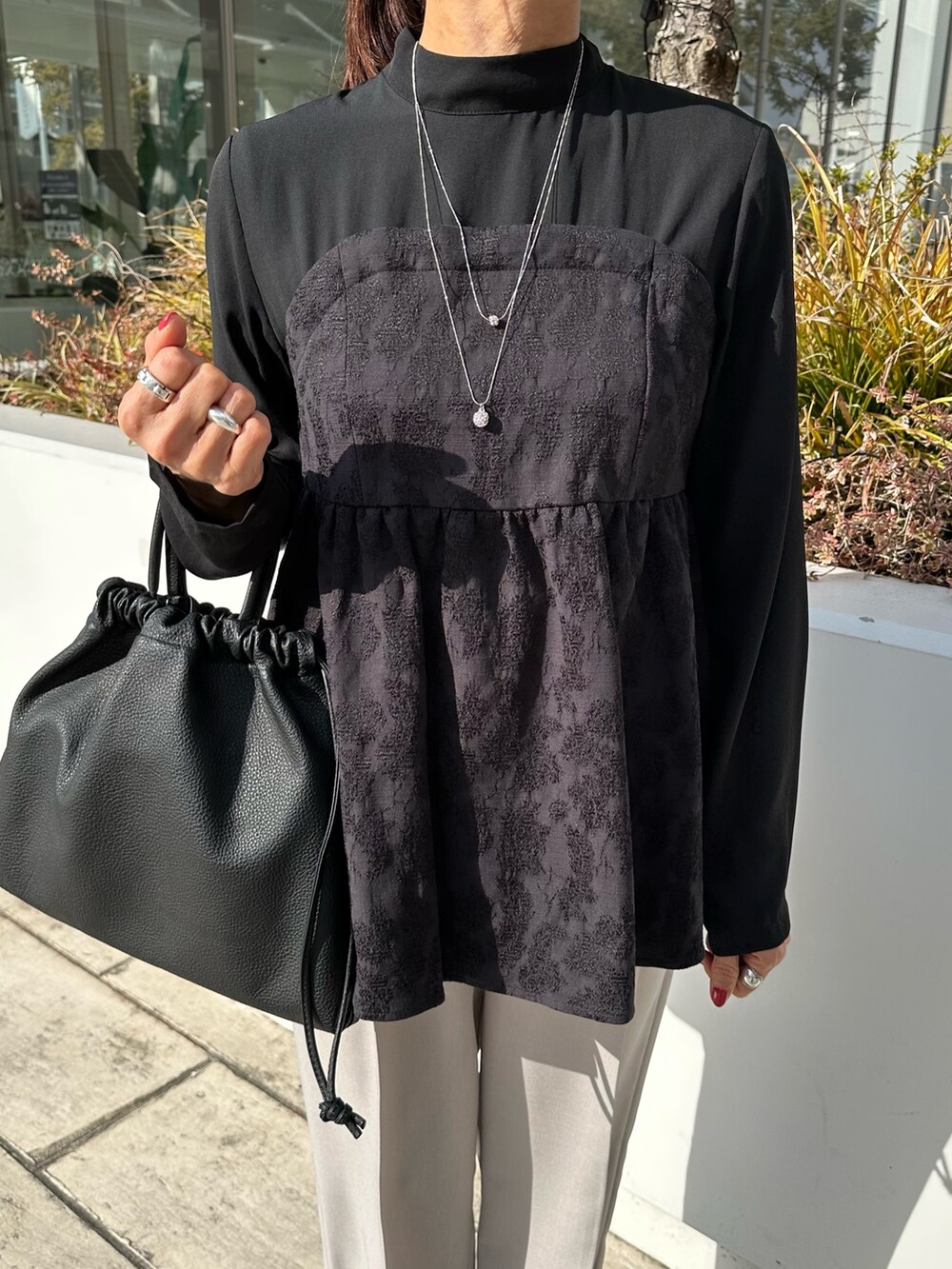 ブラック系のシャツ/ブラウス、ベージュ系のその他パンツ、ブラック系のショルダーバッグを着用したレディースの冬コーディネートの4枚目の写真