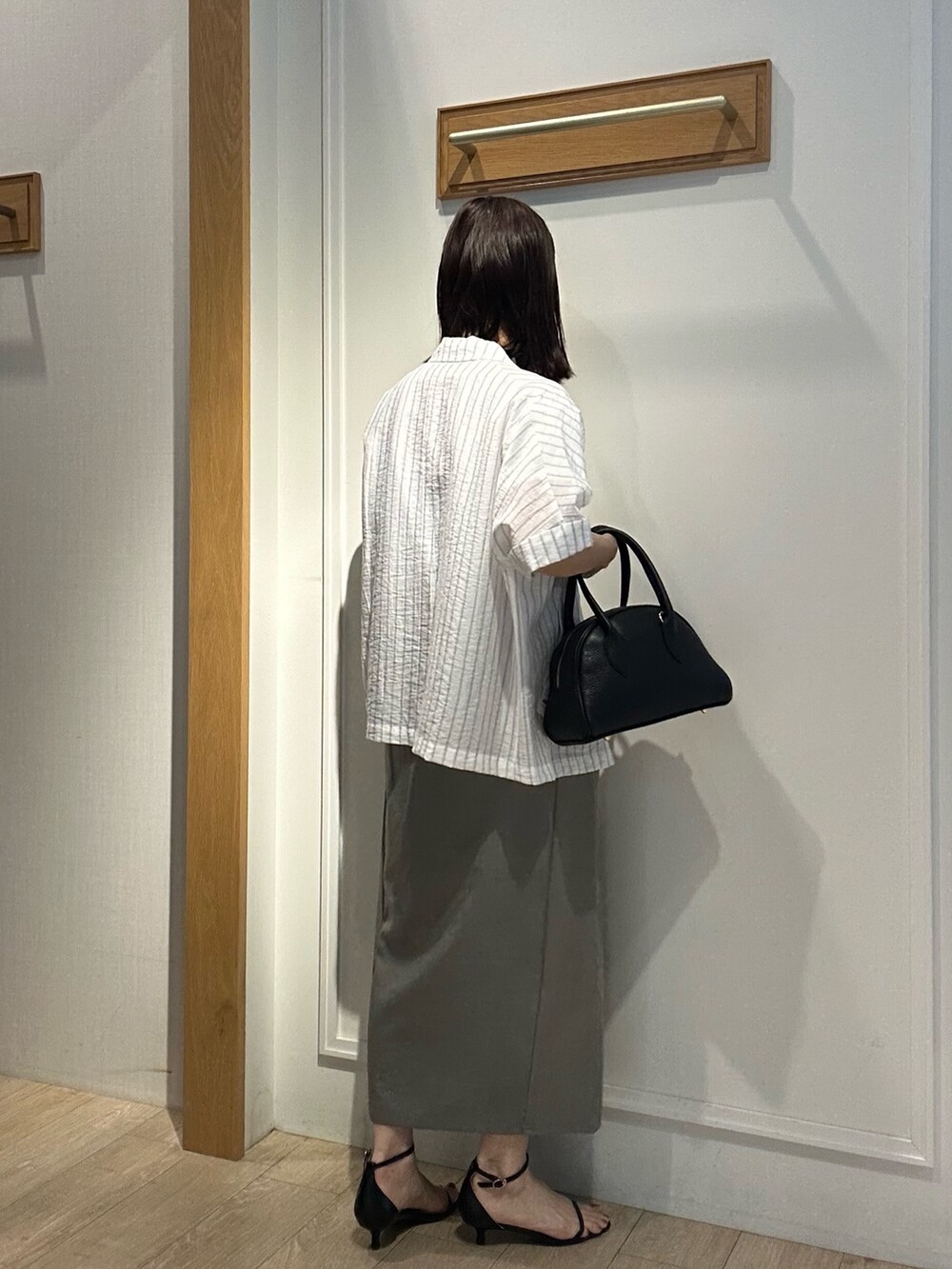 グレー系のテーラードジャケット、ホワイト系のTシャツ/カットソー、グリーン系のスカートを着用したレディースの夏コーディネートの2枚目の写真