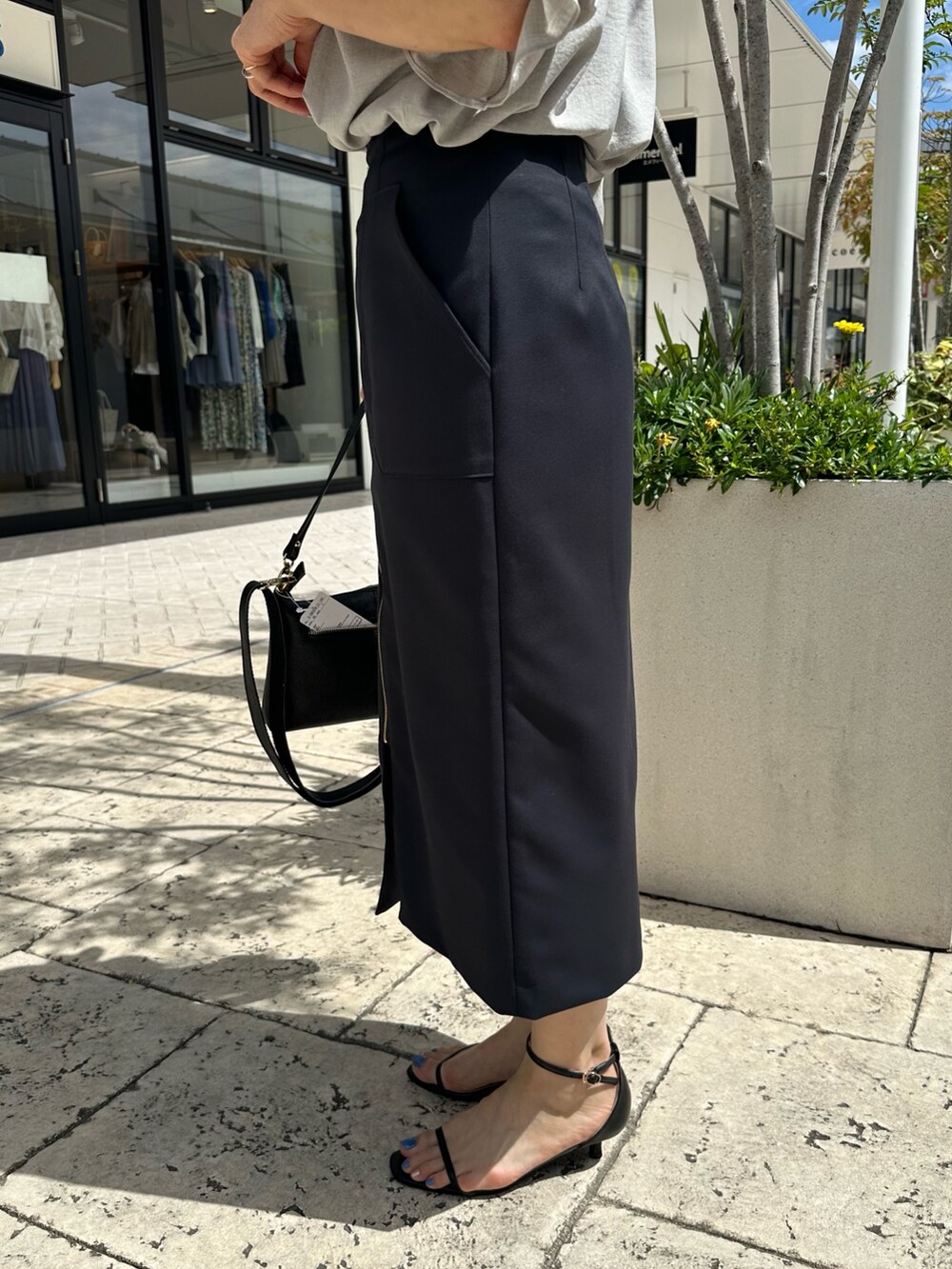 ブラック系のサンダル、ベージュ系のシャツ/ブラウス、ブルー系のスカートを着用したレディースの夏コーディネートの8枚目の写真