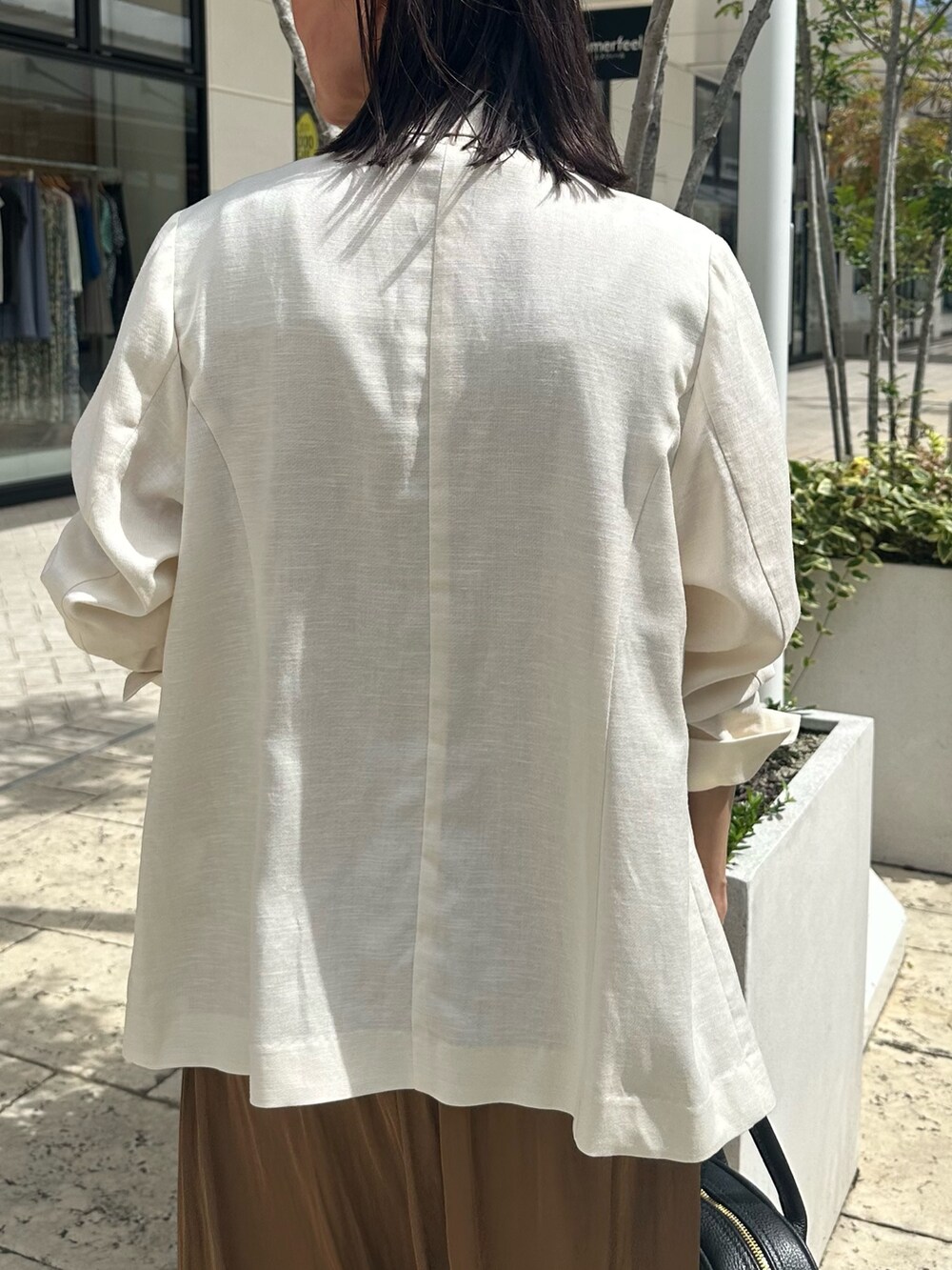 ブラウン系のワンピース、グレー系のTシャツ/カットソー、ホワイト系のテーラードジャケットを着用したレディースの夏コーディネートの9枚目の写真