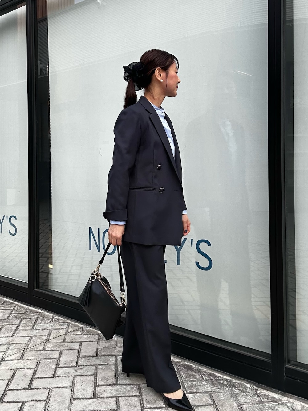 ブルー系のテーラードジャケット、ブルー系のその他パンツ、ブラック系のショルダーバッグを着用したレディースの冬コーディネートの2枚目の写真